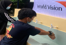 A kid uses the newly opened hygiene facility by World Vision